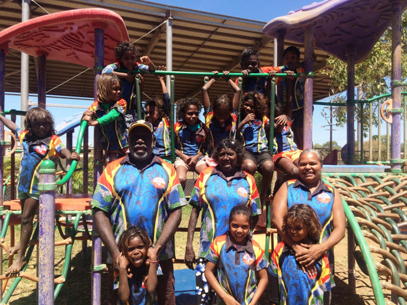 Adults and children on play equipment