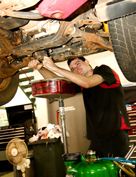 Young man working on the suspension of a car during the 2000