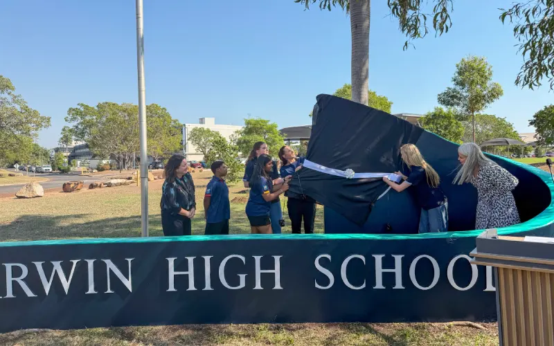 Darwin High School staff and students unveiling the school's new logo.