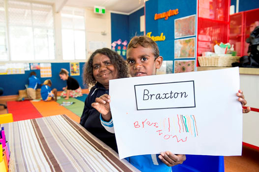 Preschool child holding up writing